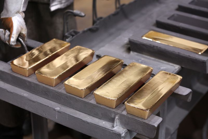 Gold bars in production being handled by worker.