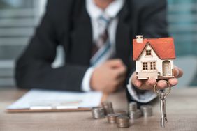 House Key in Home Insurance Broker Agent's Hand