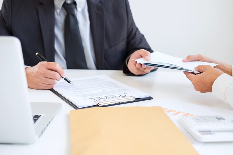 Businessman Receiving Envelope From Colleague