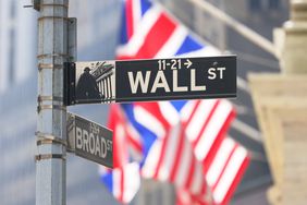 A Wall Street street sign appears in front of the New York Stock Exchange