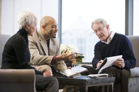Older couple discussing paperwork with a young man