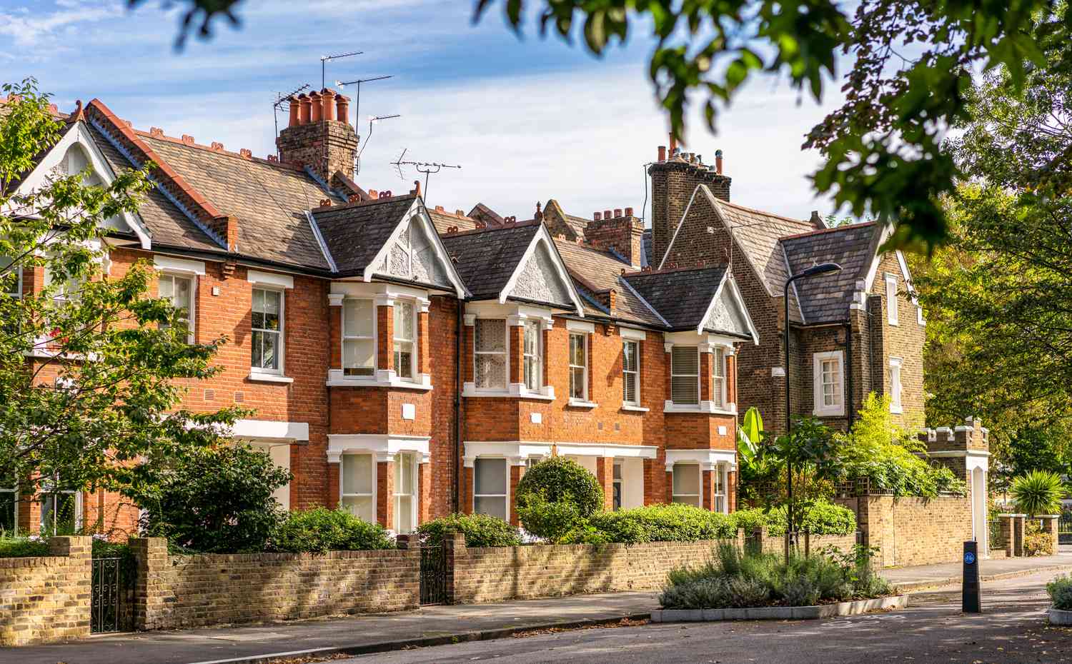 A street of traditional terraced houses, on a quiet leafy street in East London.