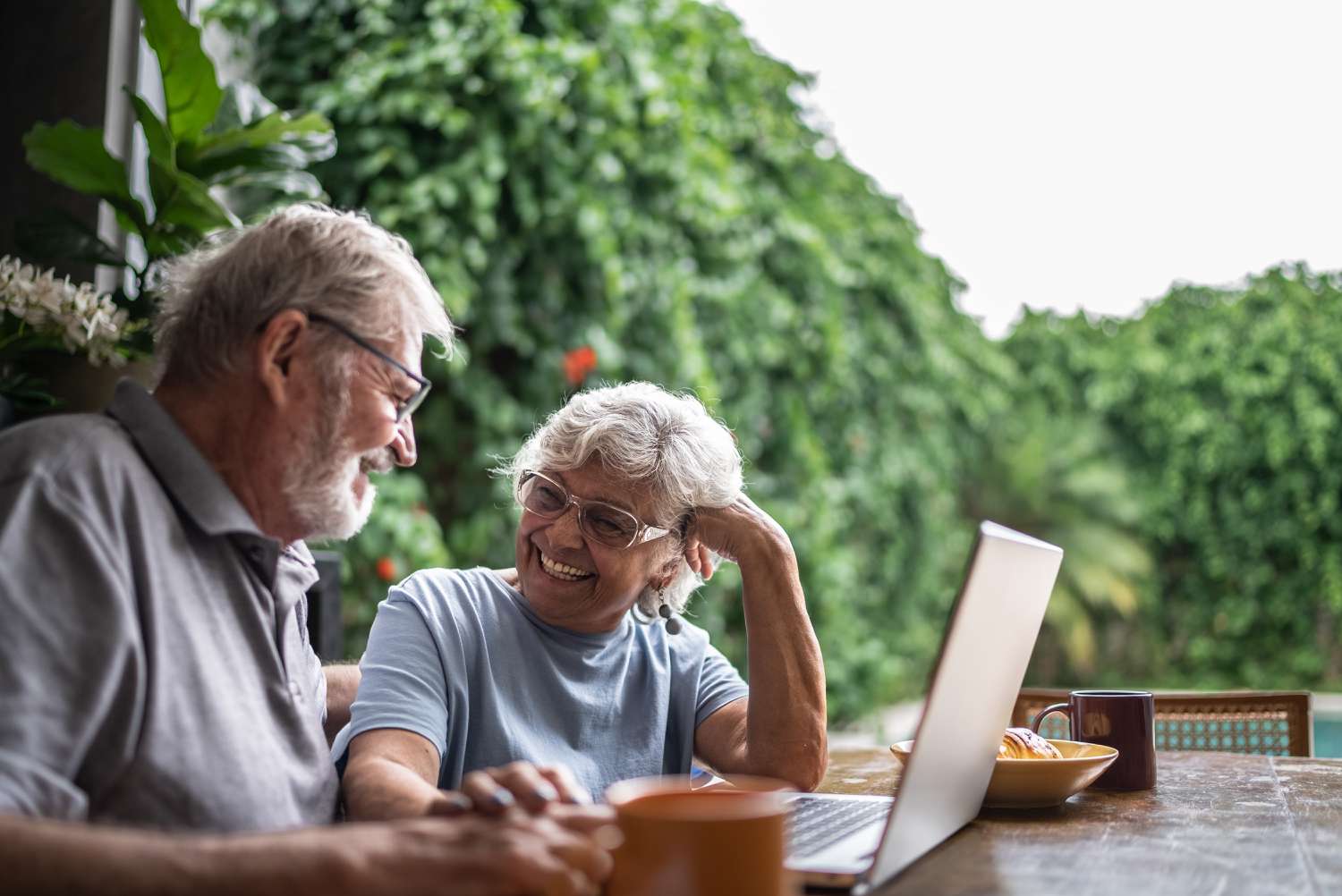Happy senior couple using the laptop at home