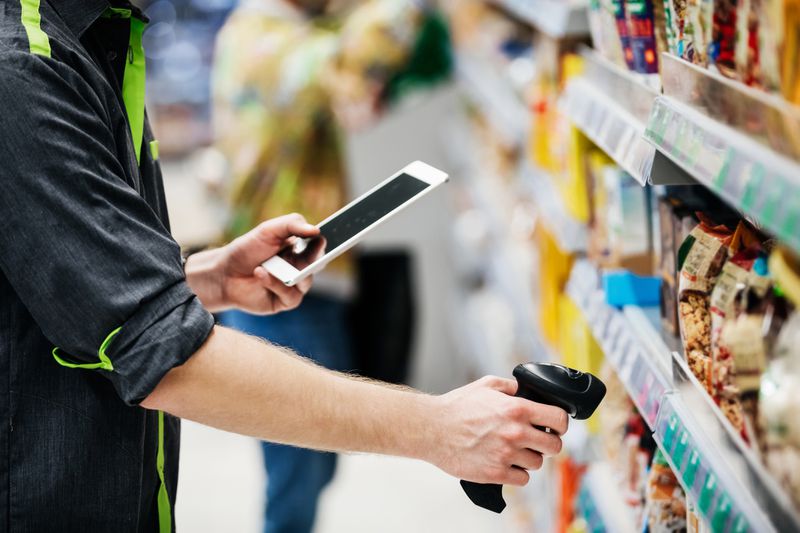 An employee scanning inventory at a grocery store.