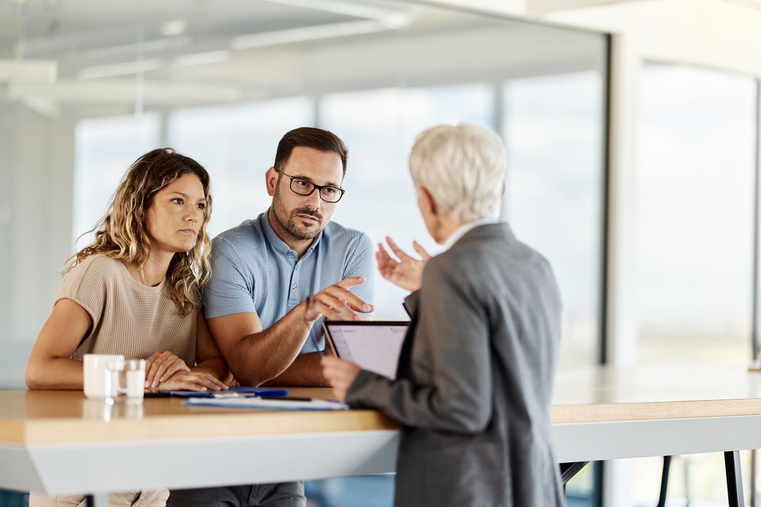 Couple talking to banker about how much cash they can deposit in the bank