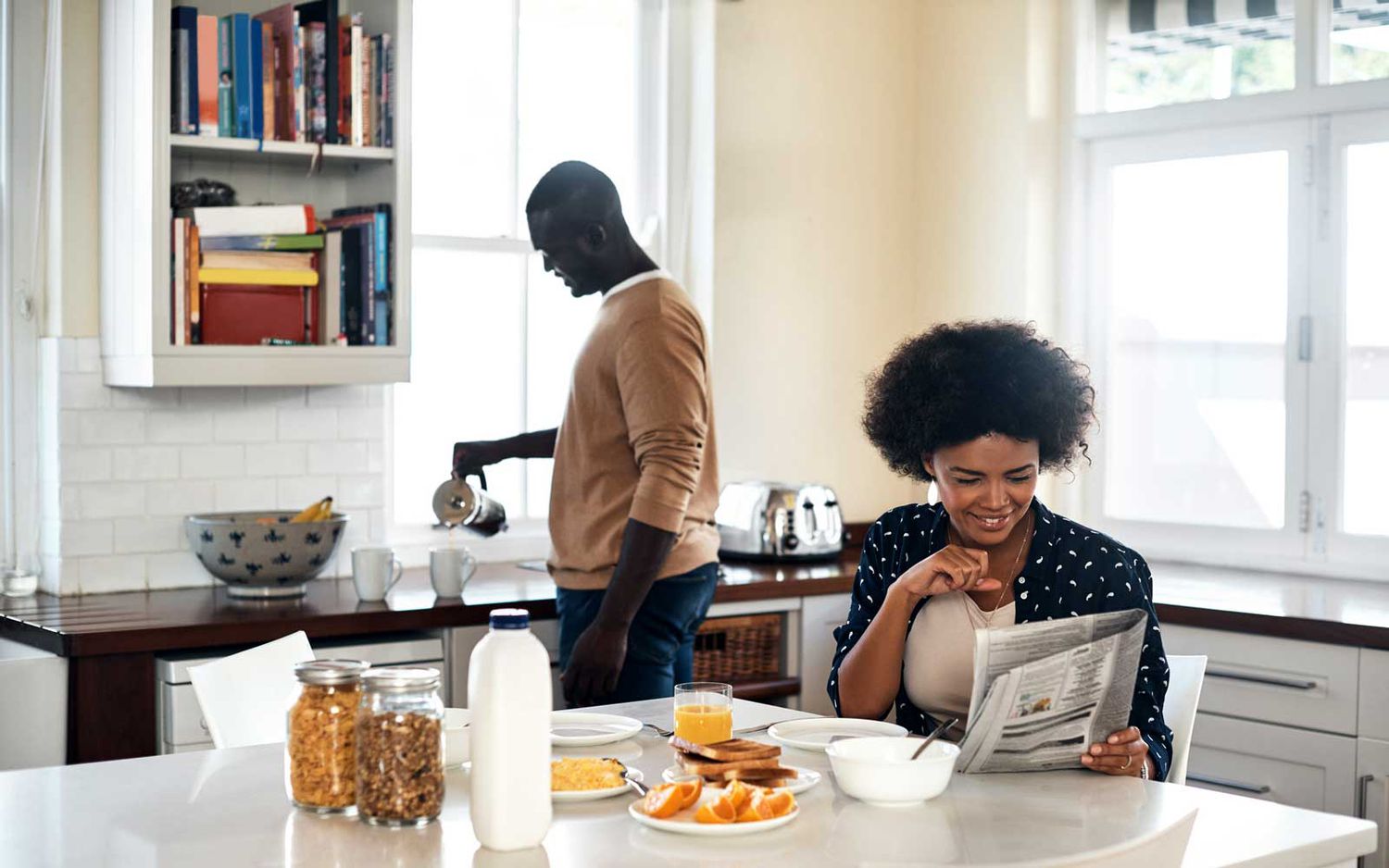 young couple having breakfast in their kitchen at home