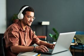 Young student in headphones checking for best bank accounts for student.