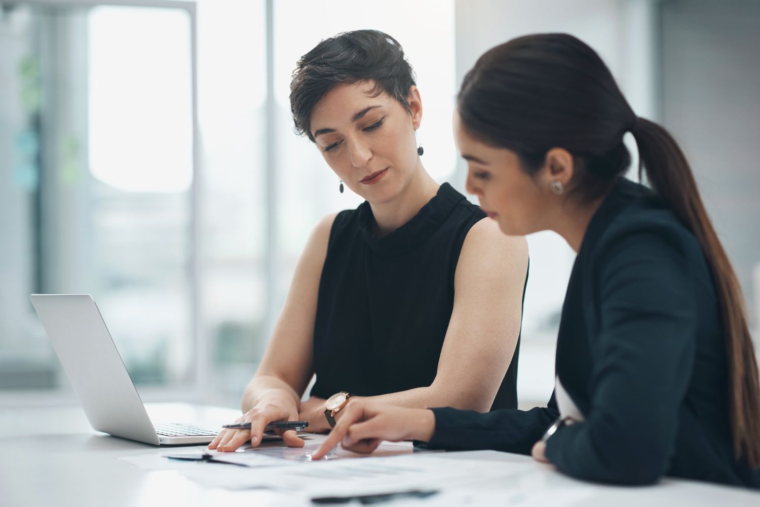 Two businesswomen review papers