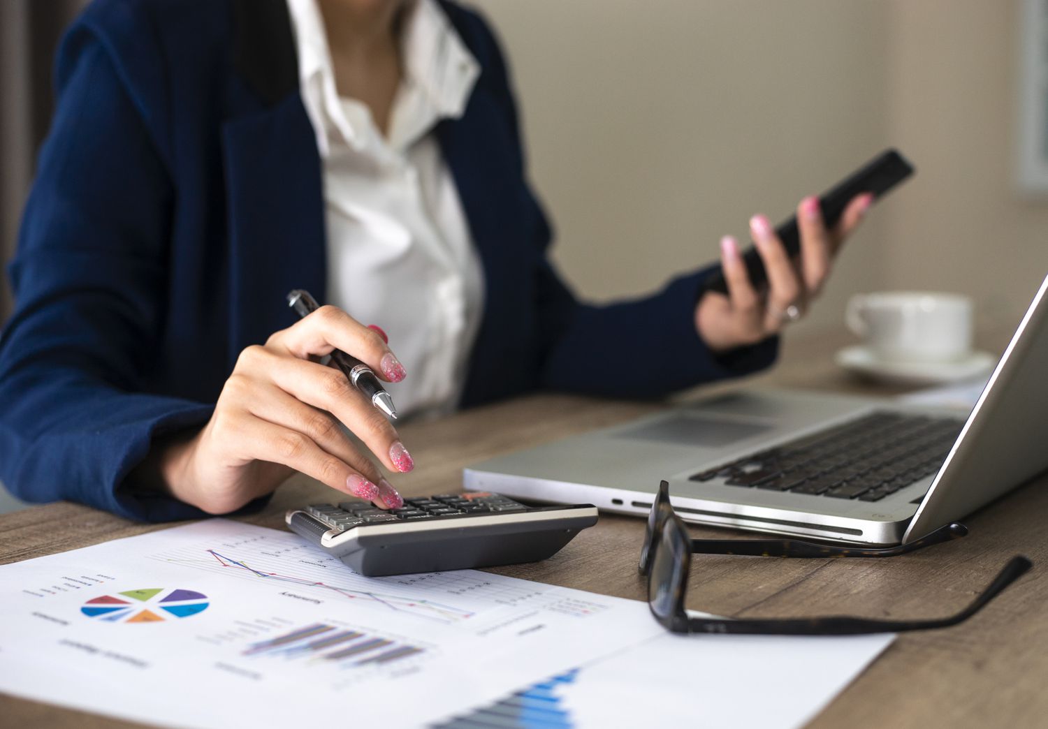 Close up of female accountant or banker making calculations. Savings, finances and economy concept