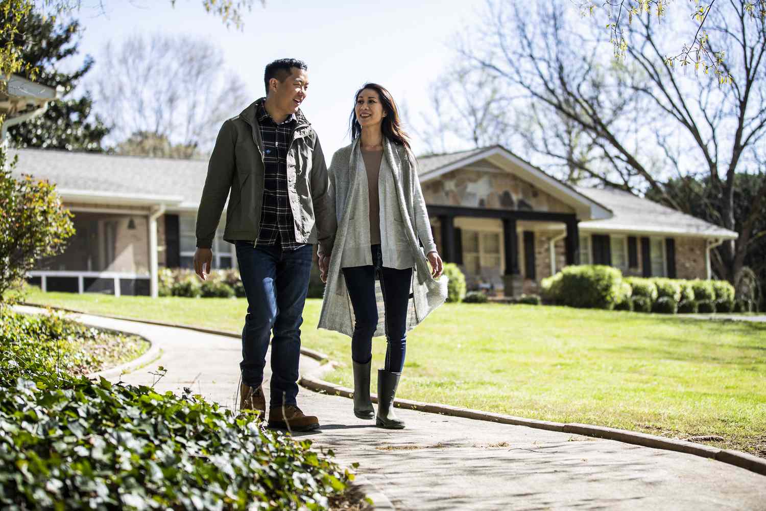 Married couple walking on pathway in front of home