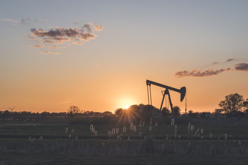oil well in a field at sunset