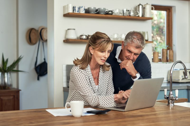 A couple at a computer in a kitchen