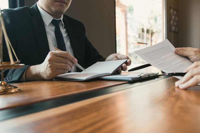 Lawyer in an office with another person going over paperwork