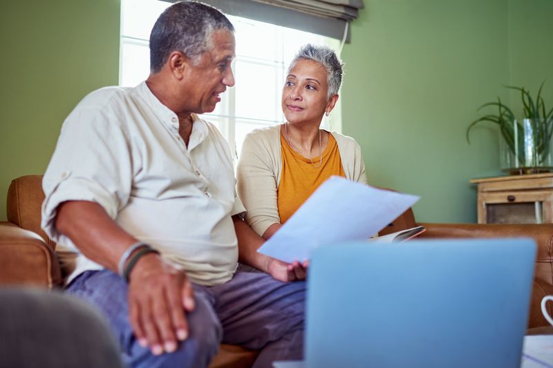 Two mature adults at a table reviewing documents together