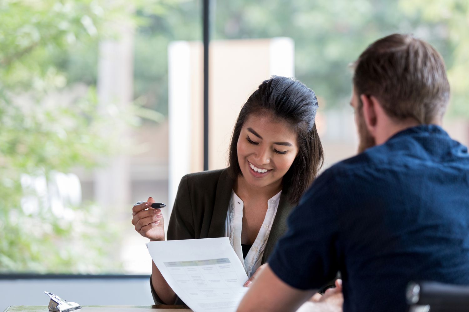 Bank employee reviewing the details of customer's deposit.