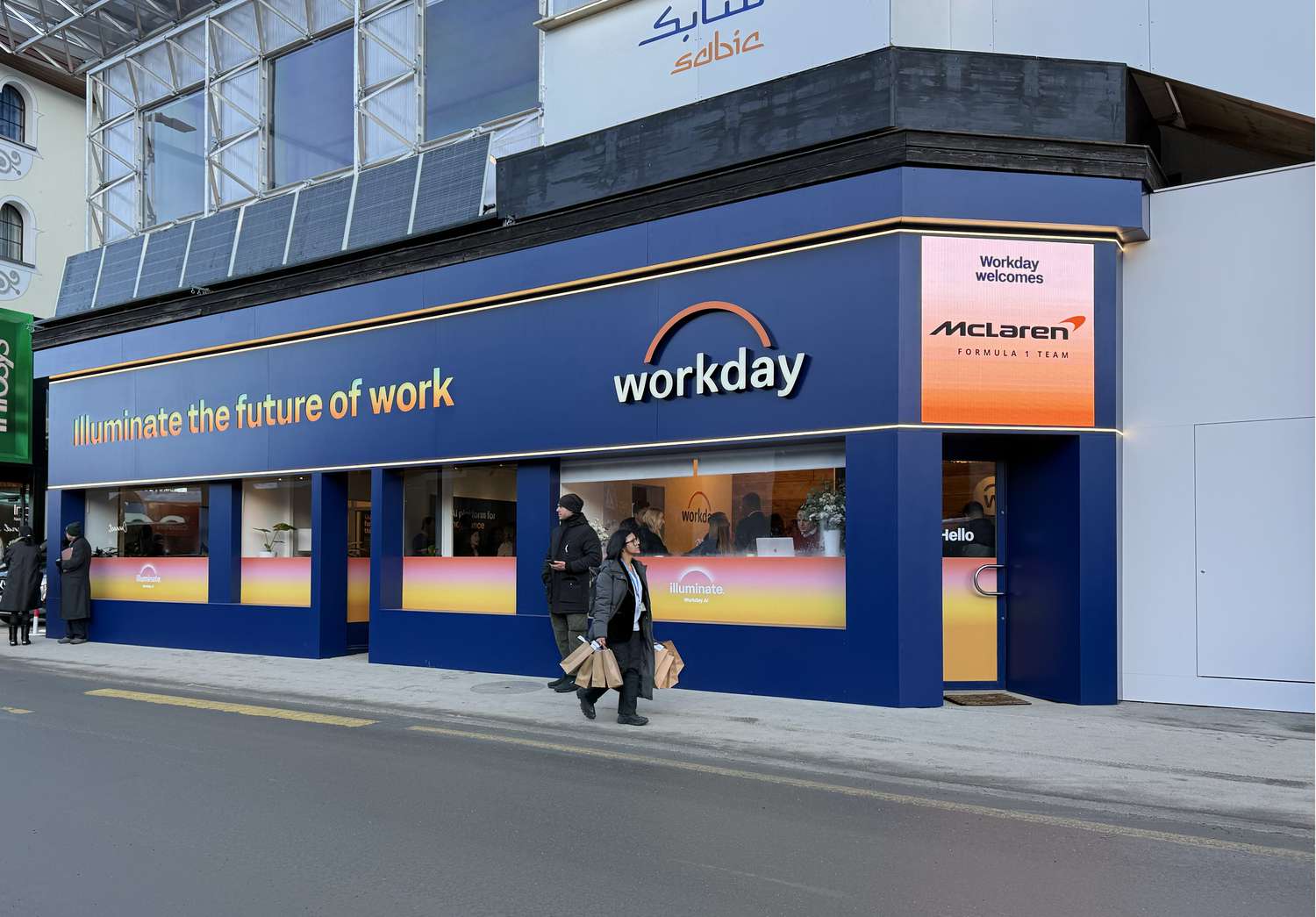 The Workday logo is seen on the outside of a blue and white building that says "Illuminate the future of work"