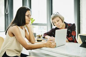 Female financial advisor reviewing data on laptop while meeting with businesswoman in office