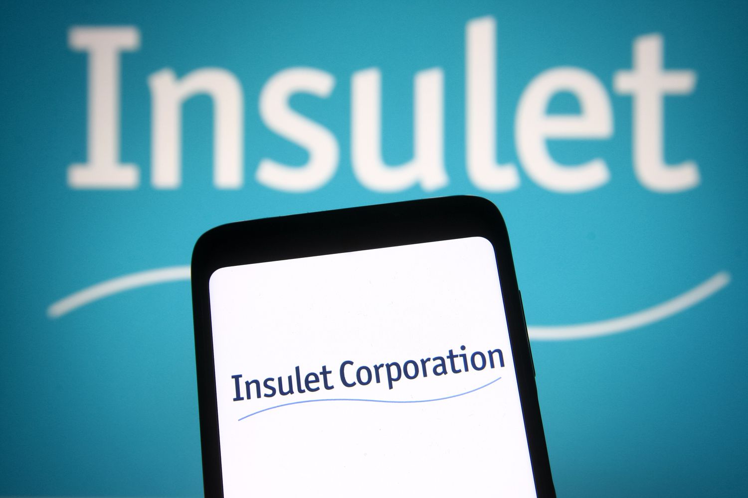 Insulet Corporation logo is seen on a smartphone and a pc screen