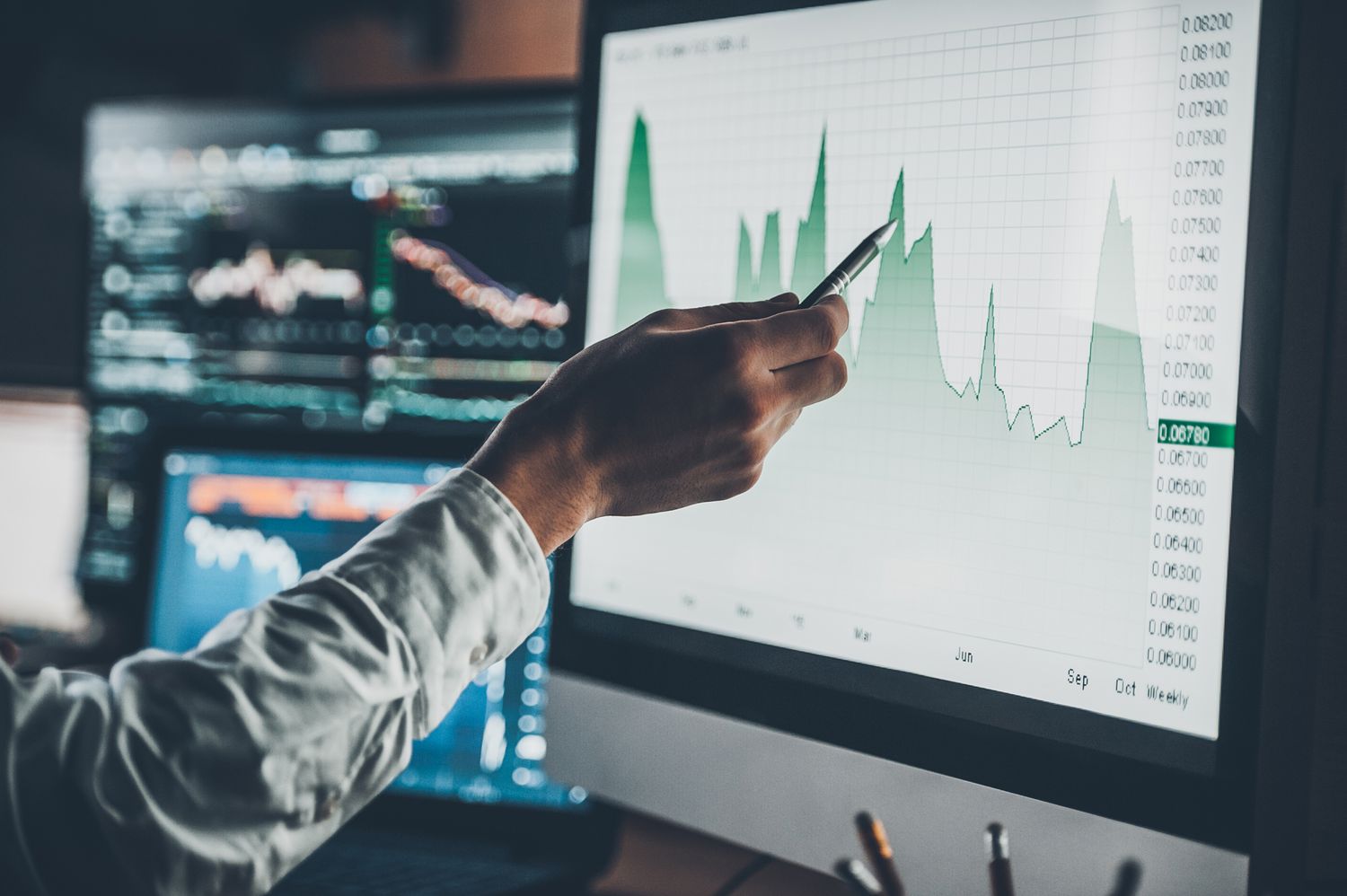 A person points to a chart on a computer screen. 