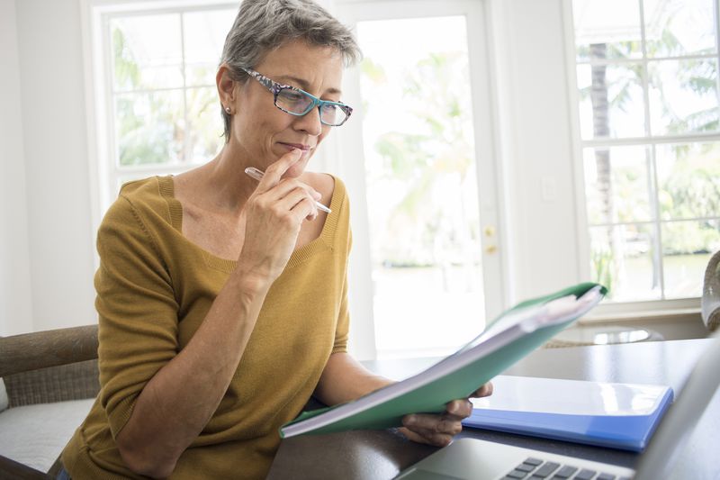 A woman reviews financial plans in folders.