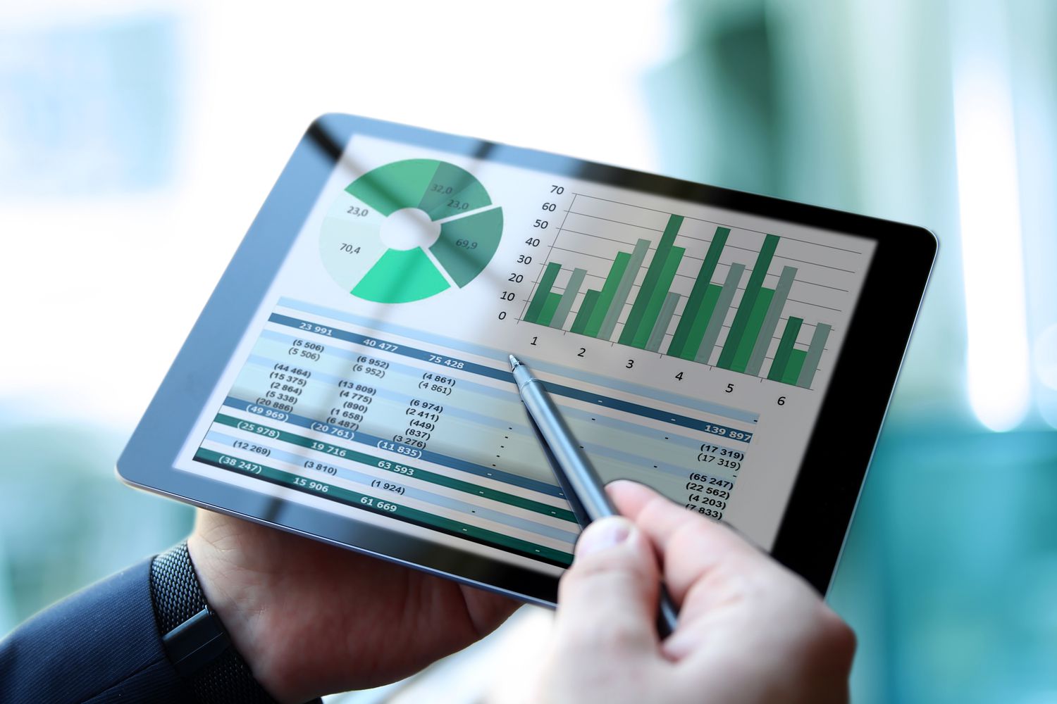 Person with a tablet computer showing business financial and stock data