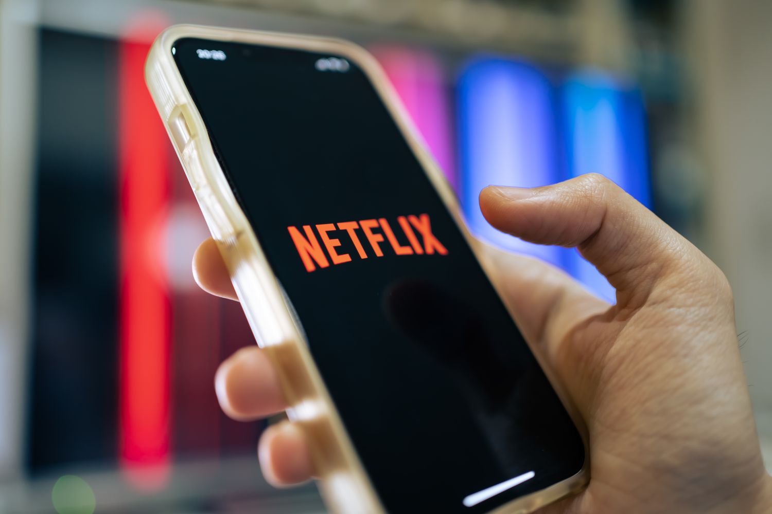 Person holding a mobile devise with Netflix on the screen