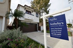 A home for sale sign in front of a house in Huntington Beach.