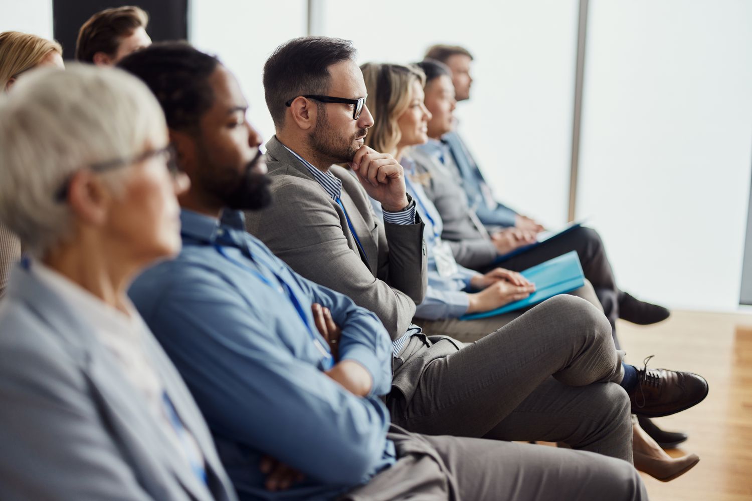 Thoughtful businessman and group of his colleagues attending a seminar in board room.