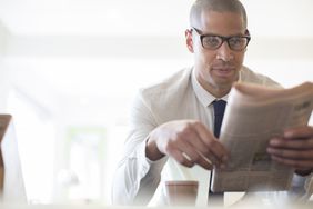Businessman reading newspaper at breakfast