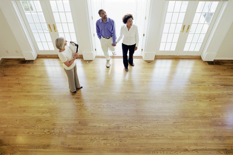 realtor showing couple interior of house, elevated view