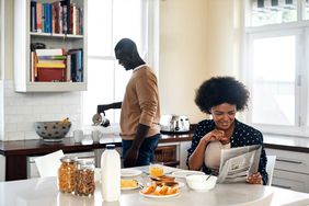 young couple having breakfast in their kitchen at home