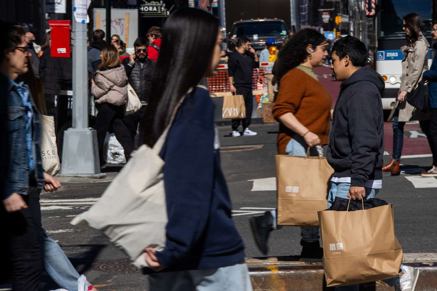 Shoppers carry Uniqlo bags in the SoHo neighborhood of New York, US, on Friday, March 8, 2024. 
