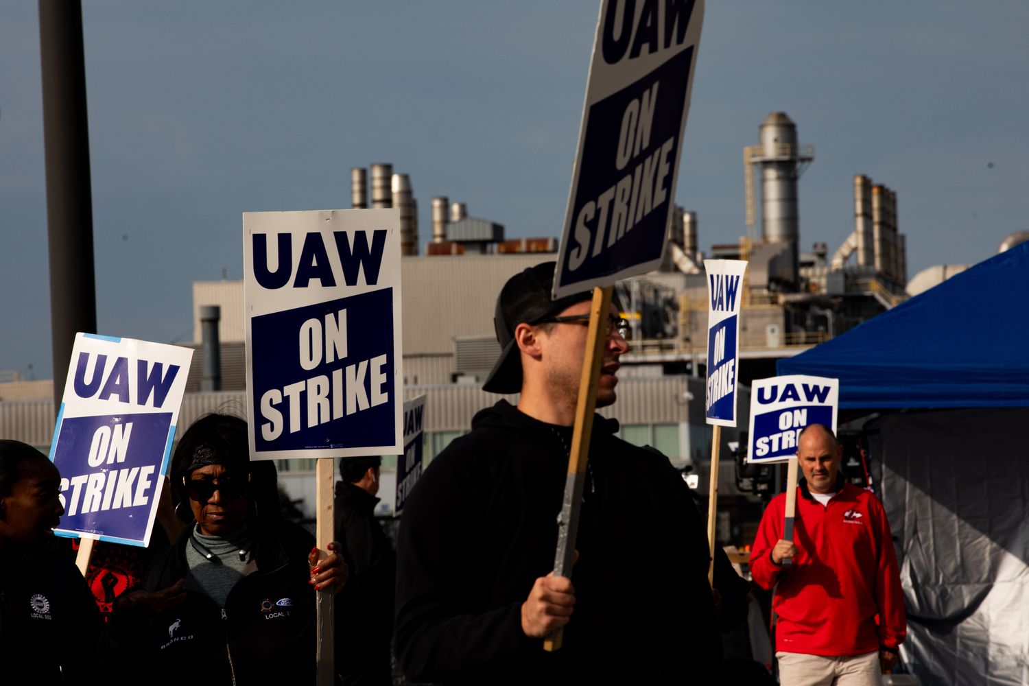People hold up United Auto Workers as the union is on strike against the Big Three. 