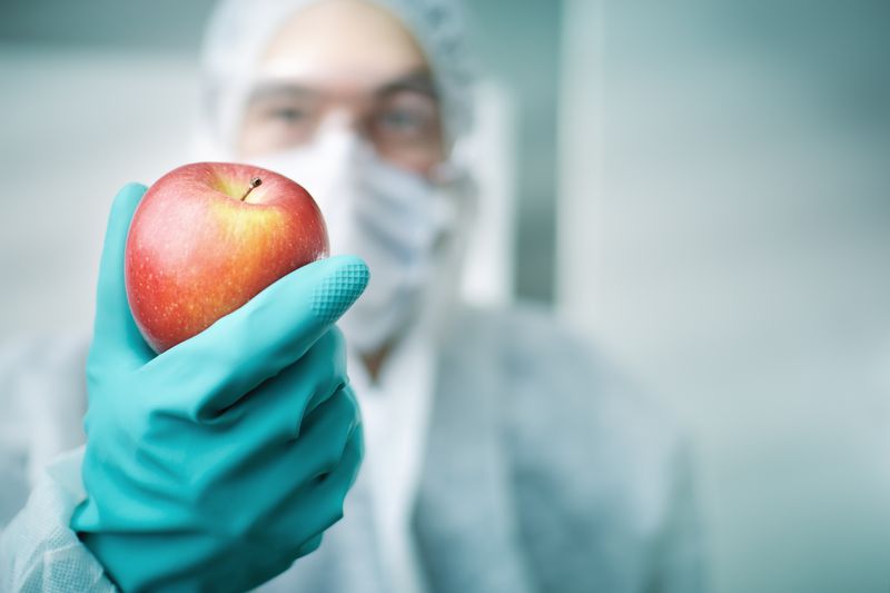 A doctor in scrubs holding an apple