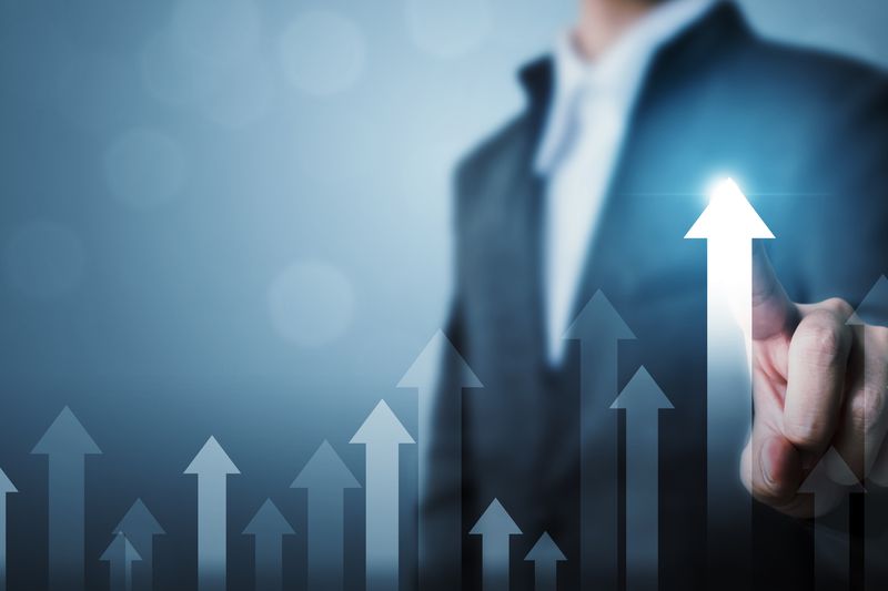 A businessman pointing an arrow graph.