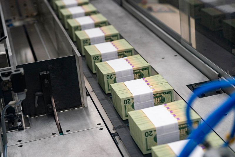 Twenty dollar notes travel through a large examining packaging equipment machine after being banded at the US Bureau of Engraving and Printing in Washington, DC, US, on Tuesday, May 21, 2024. 