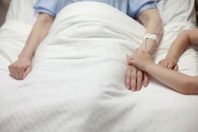 Young girl holding grandma's hand in hospital short term disability