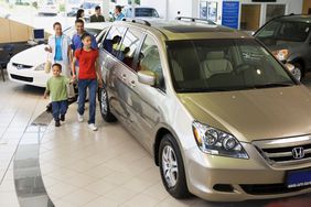 Family looking at new cars in a showroom