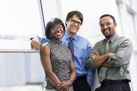 Group of three business people smiling at camera