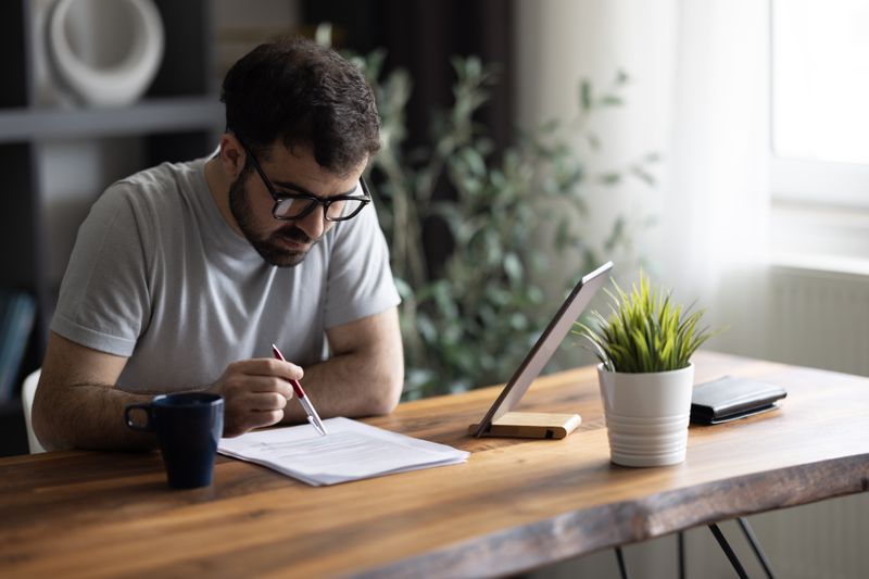 A man reviews documents at a desk.
