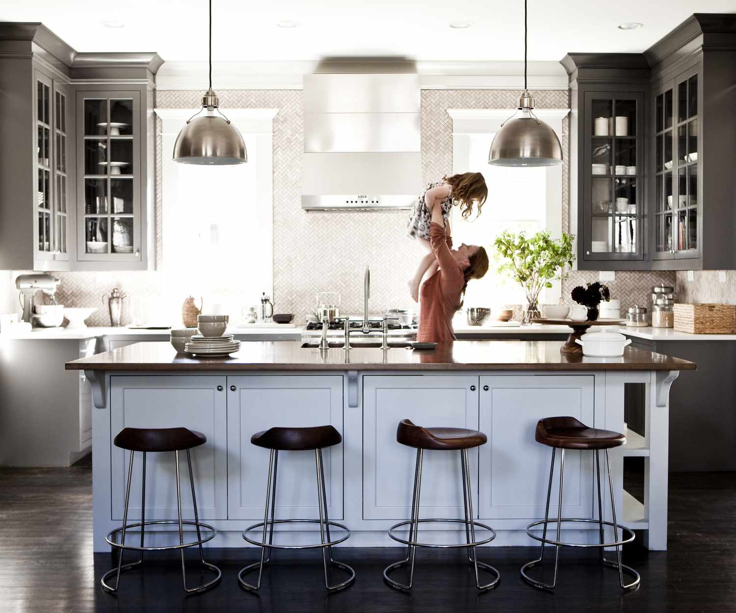 Mother lifting daughter in kitchen