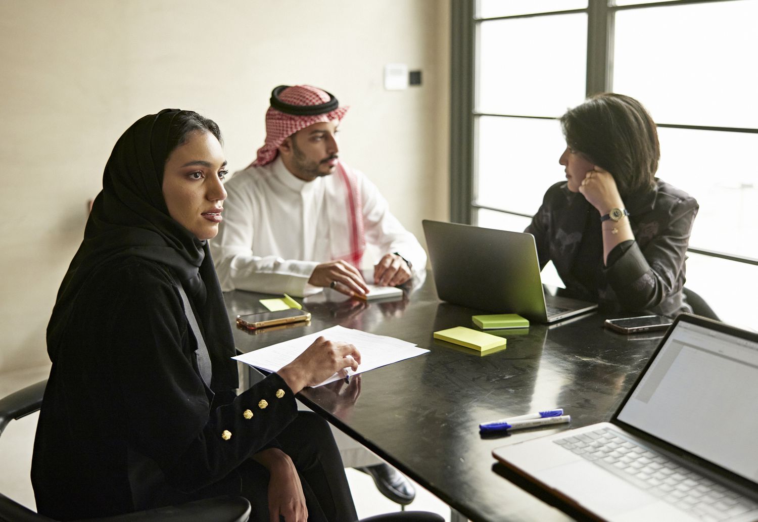 Saudi business executives meet in a conference room to complete SEC forms necessary to list the company on a U.S. exchange.