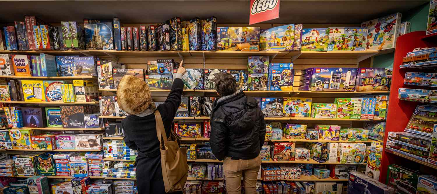 Shoppers look at toys at a store. 