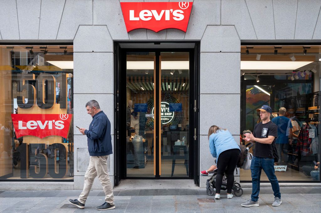 Pedestrians walk past Levi's store.
