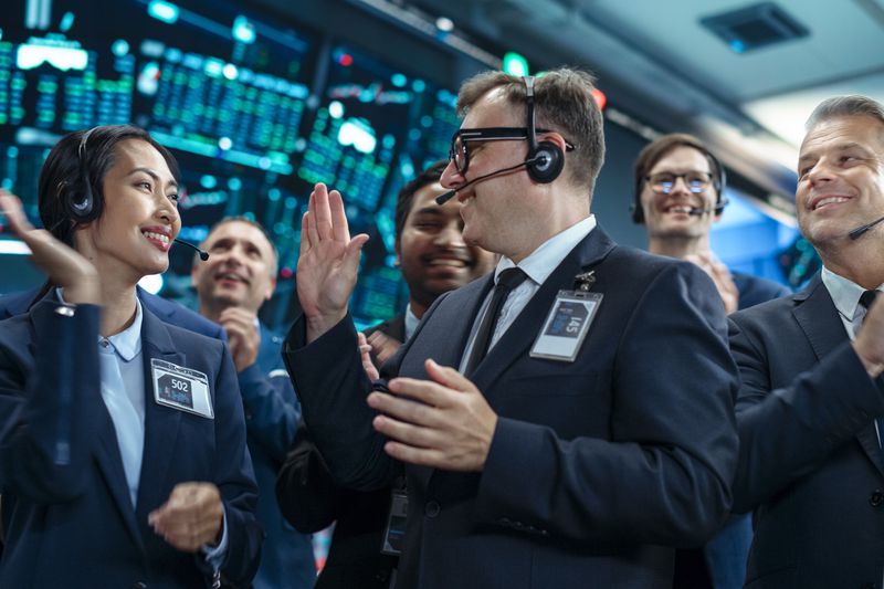Professional brokerage traders congratulate each other after completing the execution of a large step-out trade.