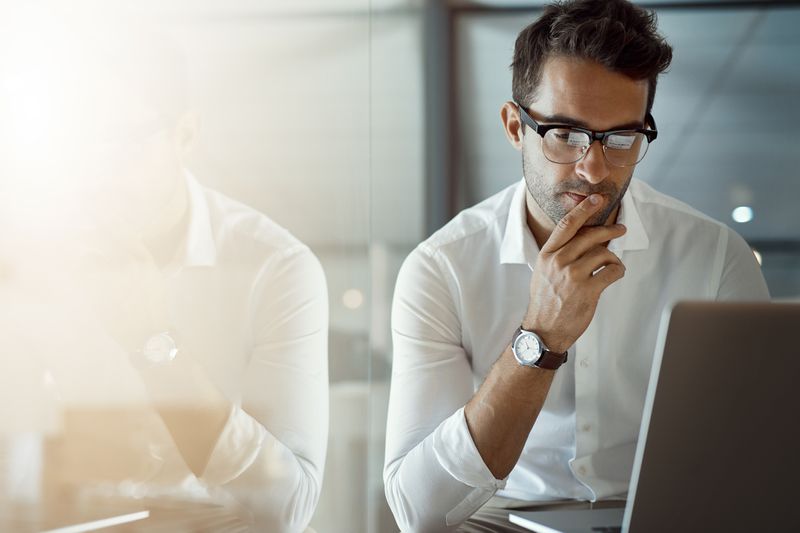 Male worker in office looking at laptop