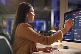 Woman looks at financial numbers on an office computer 