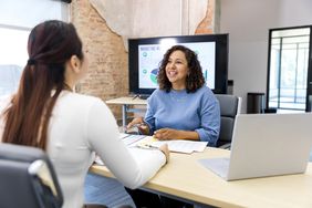 A new employee sits in the office of the human resource manager and learns about options for the company 401-k retirement plan. 