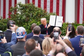 President Donald Trump signs an executive order after announcing a plan for tariffs on imported goods during an event Wednesday, April 2, 2025, in the Rose Garden at the White House