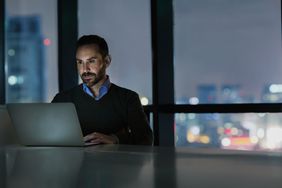 Person using a laptop after dark
